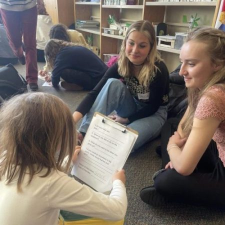 secondary students assisting a younger student